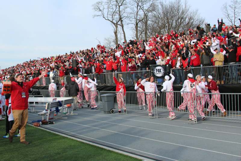 a group of people in striped red and white outfits on a track