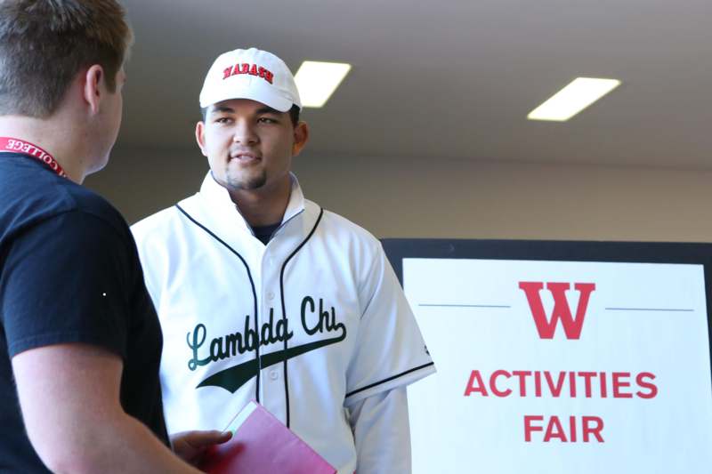 a man in a baseball uniform talking to another man