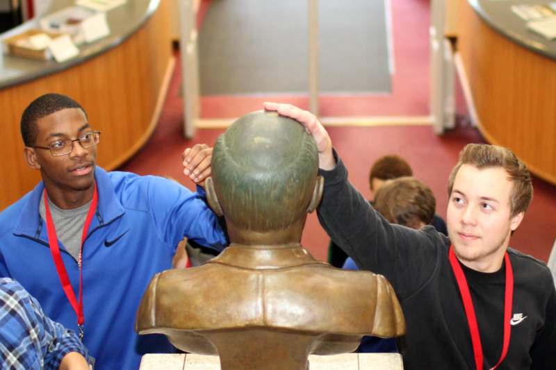 a man touching a statue of a man's head