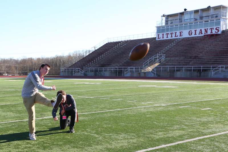 a man kicking a football on a football field