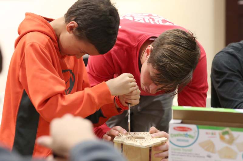 a group of boys working on a wood object