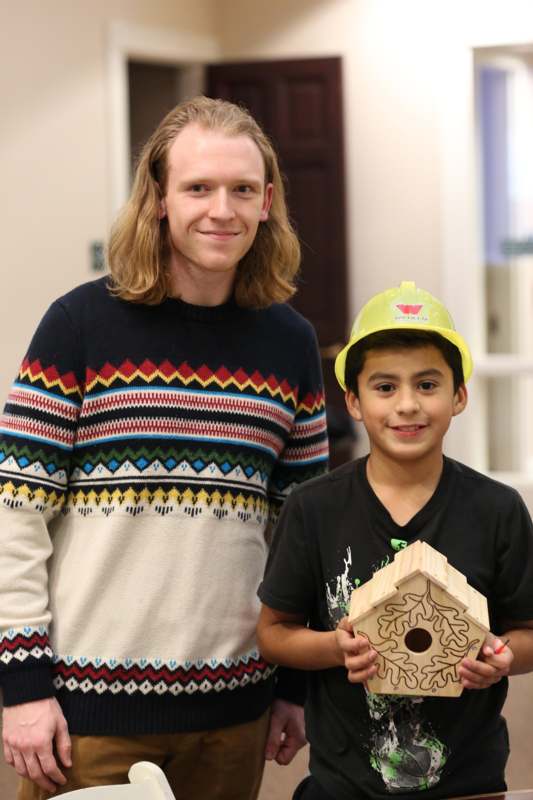 a man and boy holding a birdhouse
