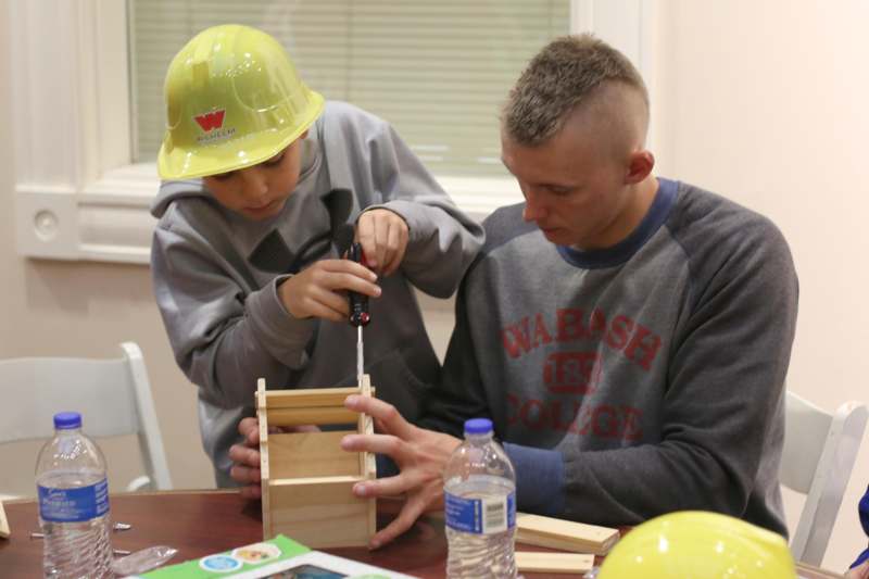 a man and boy working on a wood box