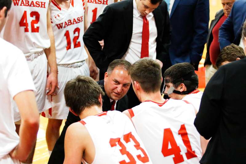 a coach in a basketball uniform with his team