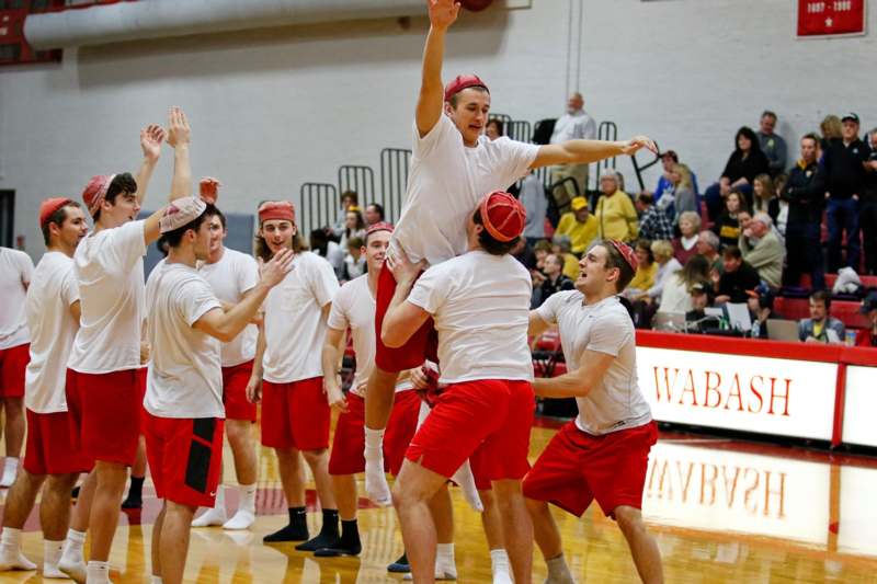 a group of men in red shorts and white shirts playing basketball