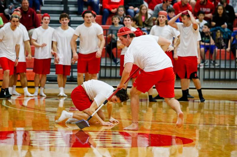 a group of people in red shorts and white shirts on a gym floor