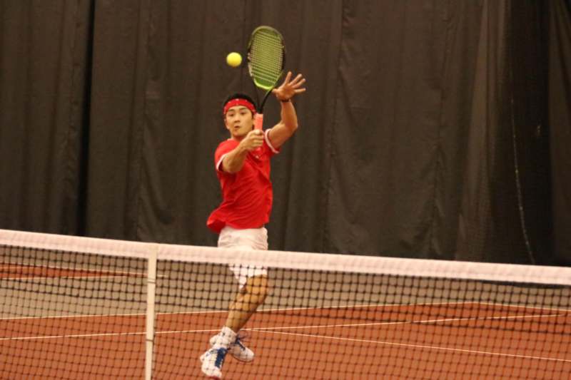 a man hitting a tennis ball with a racket