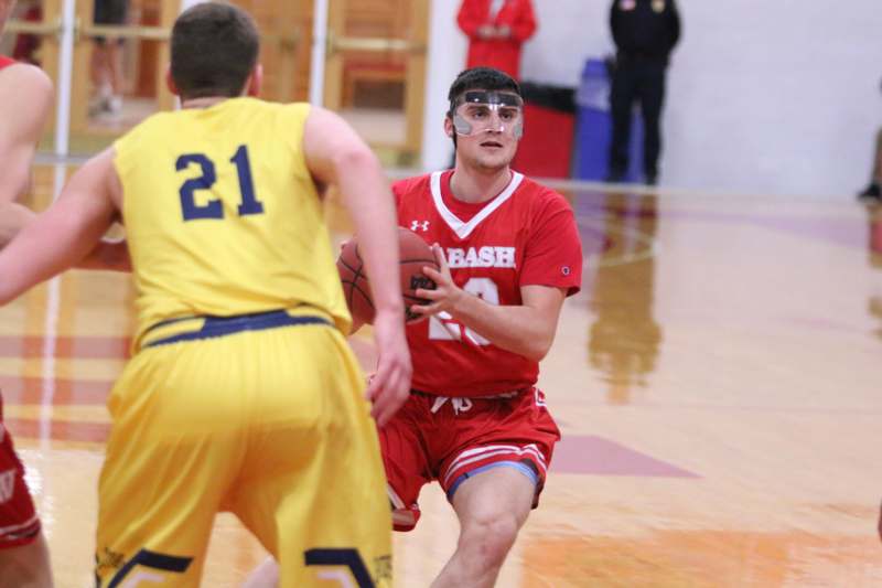 a man in a red uniform running with a basketball