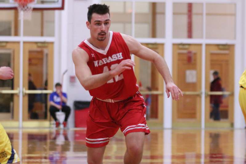 a man in a red uniform running on a basketball court