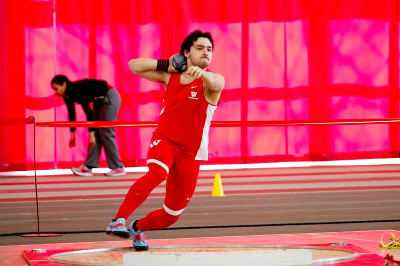 a man in a red uniform throwing a javelin