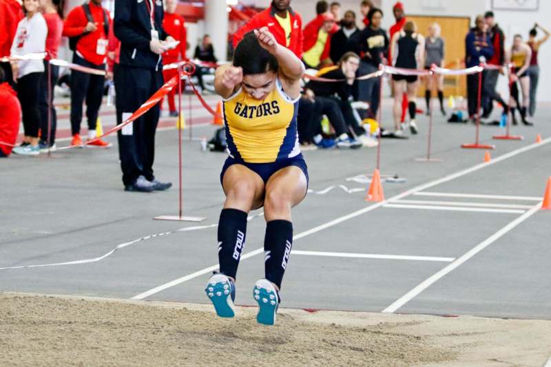 a woman jumping over a track