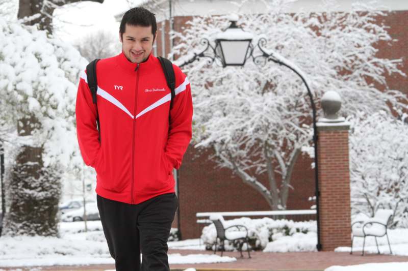 a man in a red jacket walking in the snow