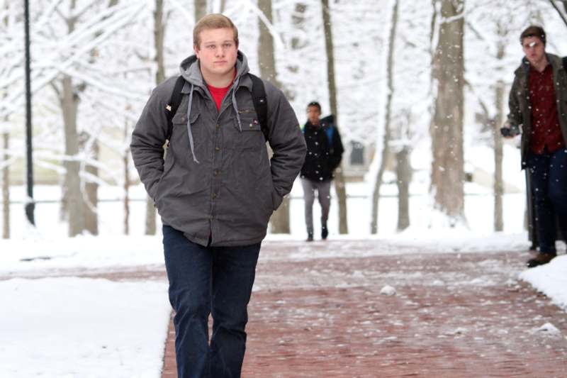 a man walking on a path with snow on the ground