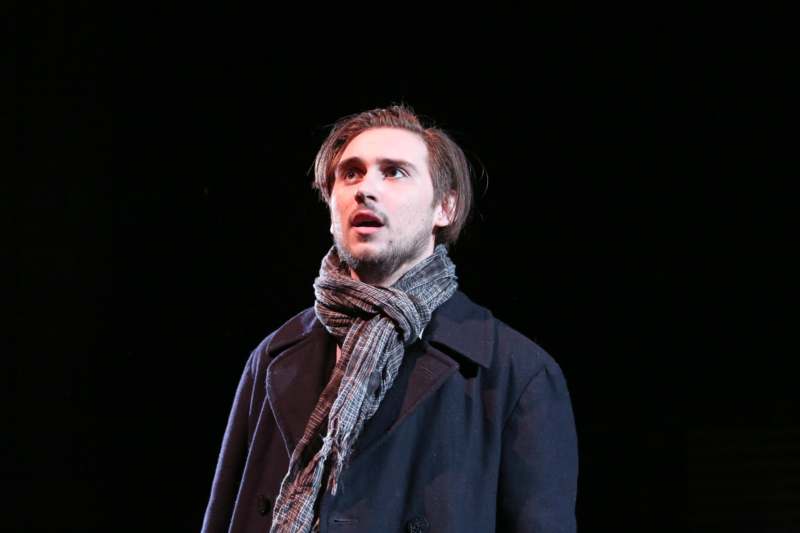 a man in a coat and scarf looking up