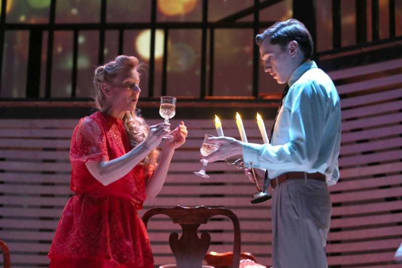 a man and woman holding wine glasses and candles