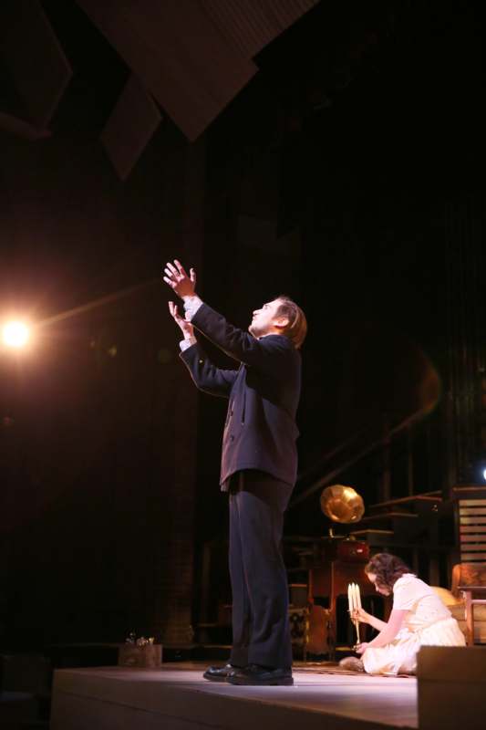 a man standing on a stage with his hands up