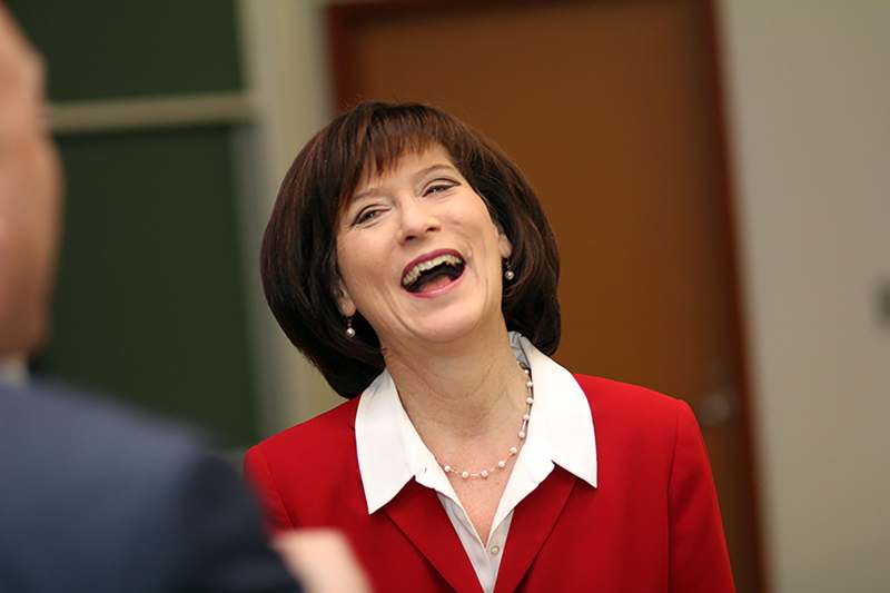 a woman in a red suit laughing