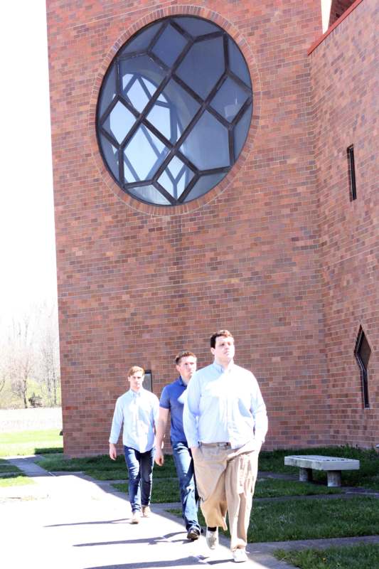 a group of men walking in front of a brick building