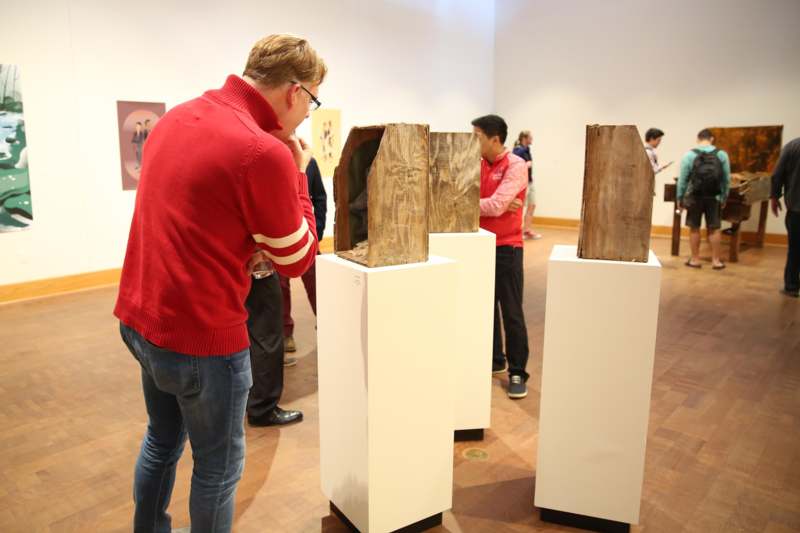 a group of people looking at wooden pieces in a room
