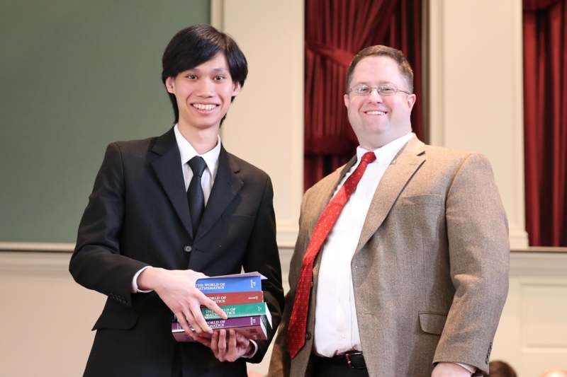 a man holding books and smiling