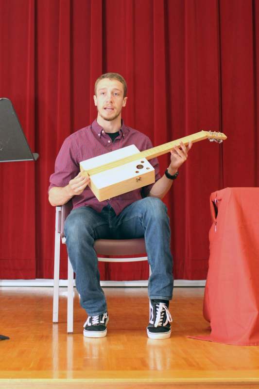 a man sitting in a chair holding a guitar