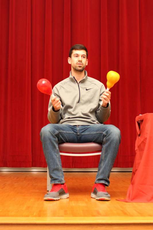 a man sitting on a chair holding two maracas