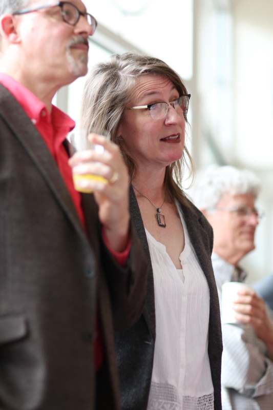 a woman holding a drink and a man in a suit