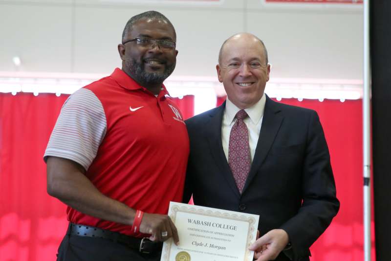 a man holding a certificate and smiling