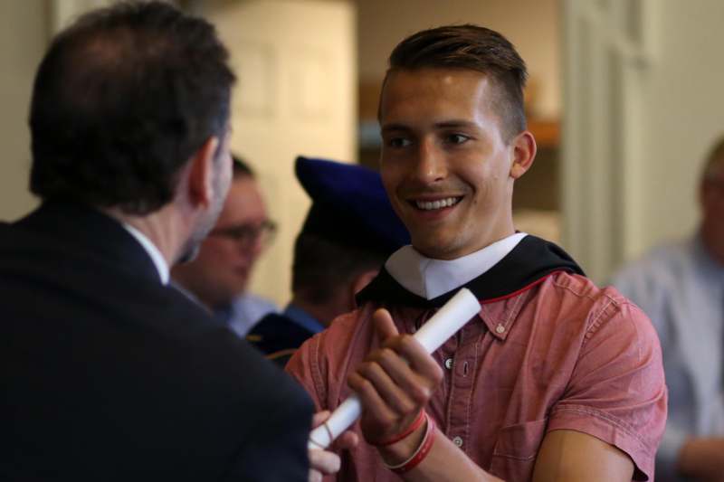 a man holding a diploma