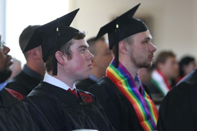 a group of men in graduation gowns and caps