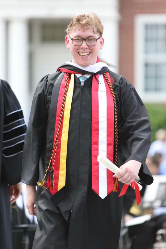 a man wearing a graduation gown and a robe