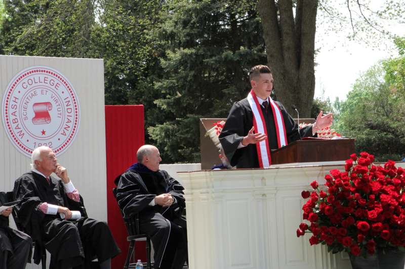 a man in a robe speaking at a podium