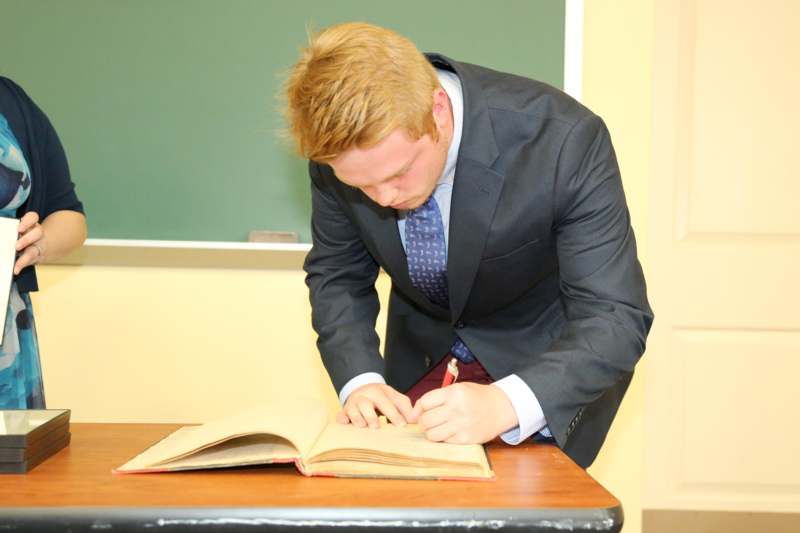a man in a suit writing on a book