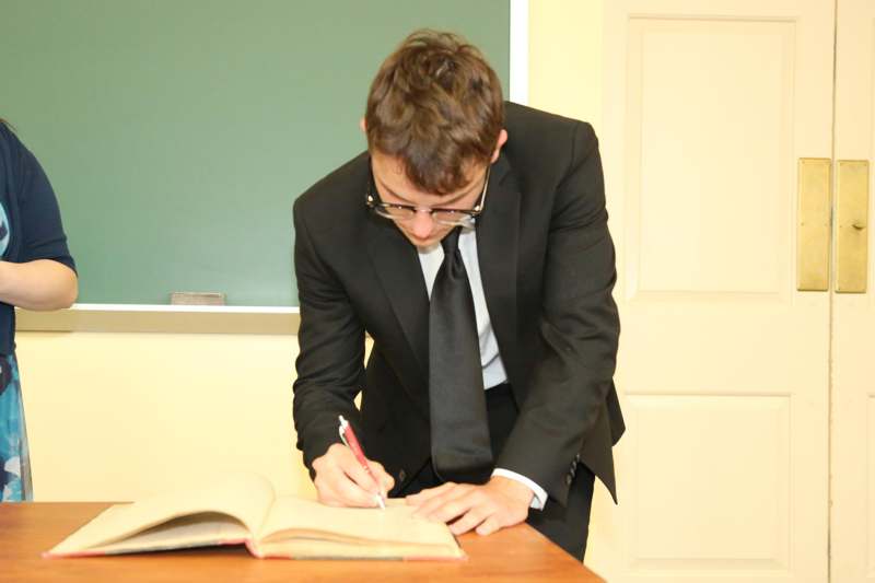 a man in a suit writing on a book