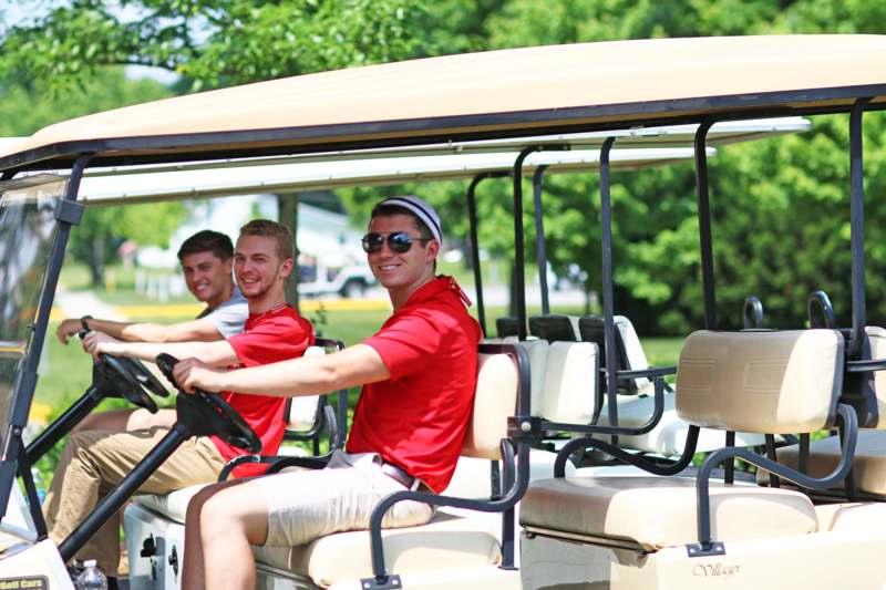 a group of men driving golf carts