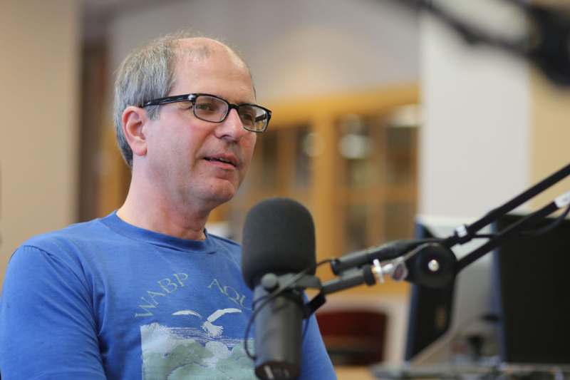 a man in glasses speaking into a microphone