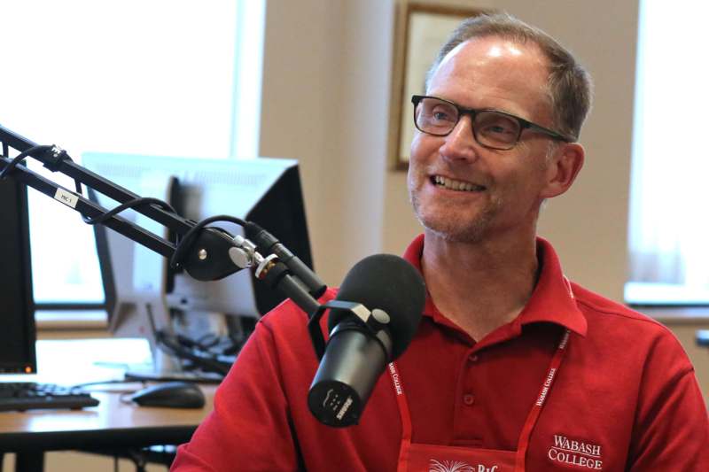 a man in red shirt and glasses smiling