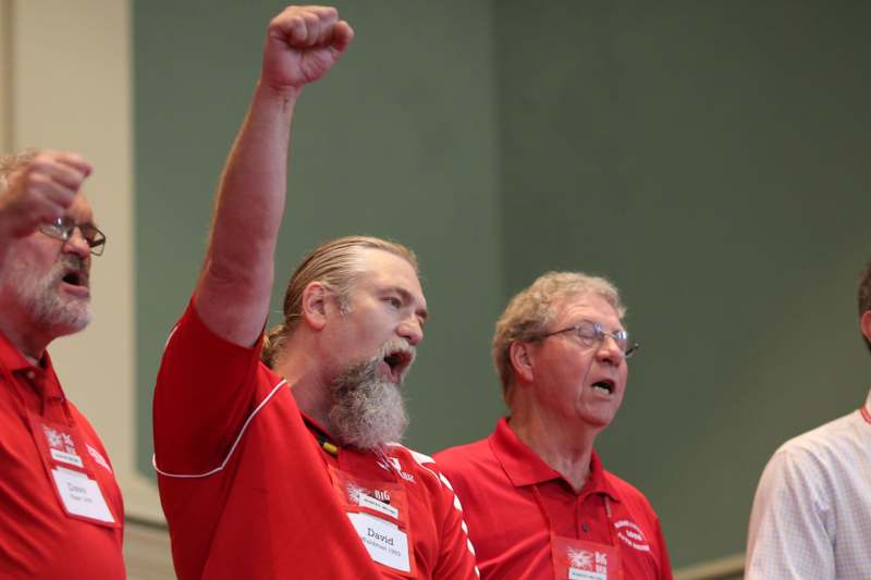 a man in red shirt with his fist raised