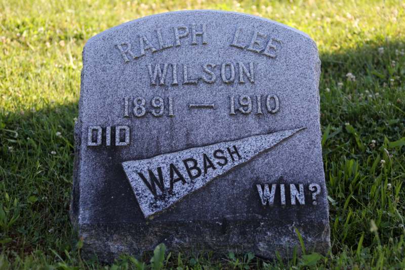 a tombstone in a grassy field