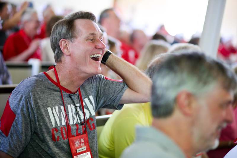 a man laughing at a conference