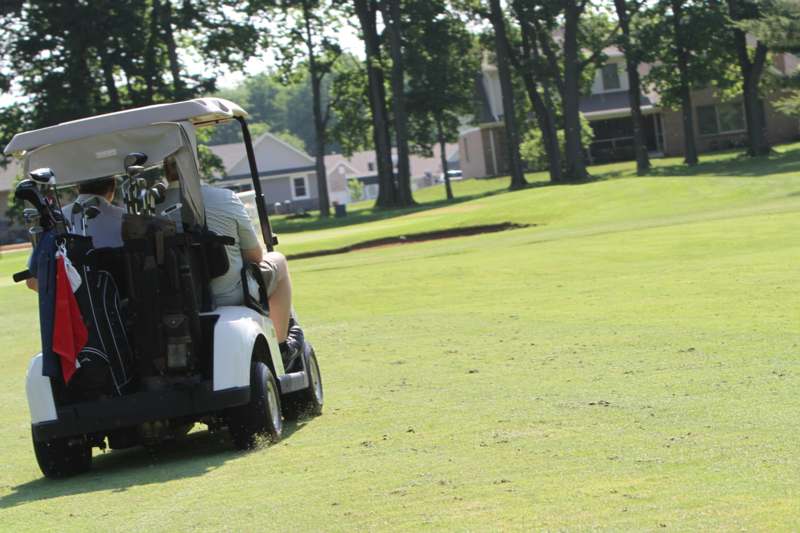 a man driving a golf cart