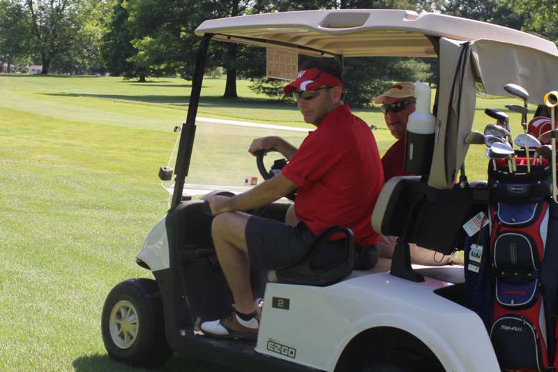 two men driving a golf cart