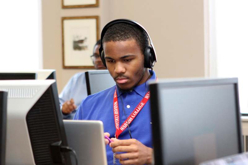 a man wearing headphones and looking at a computer screen