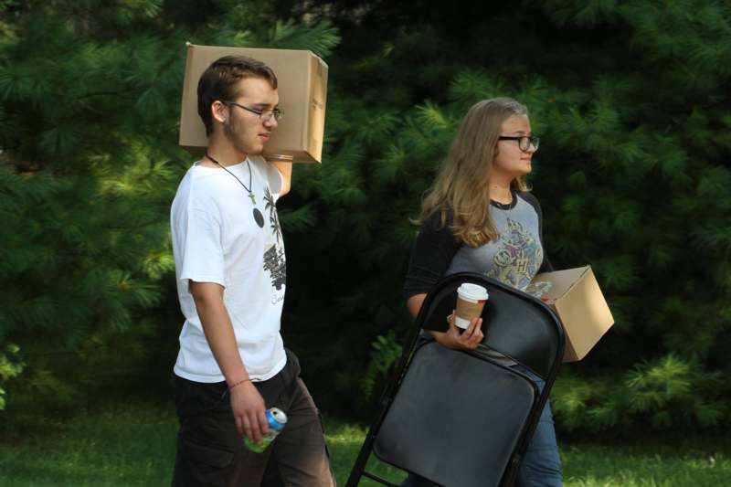 a man and woman carrying boxes and drinks