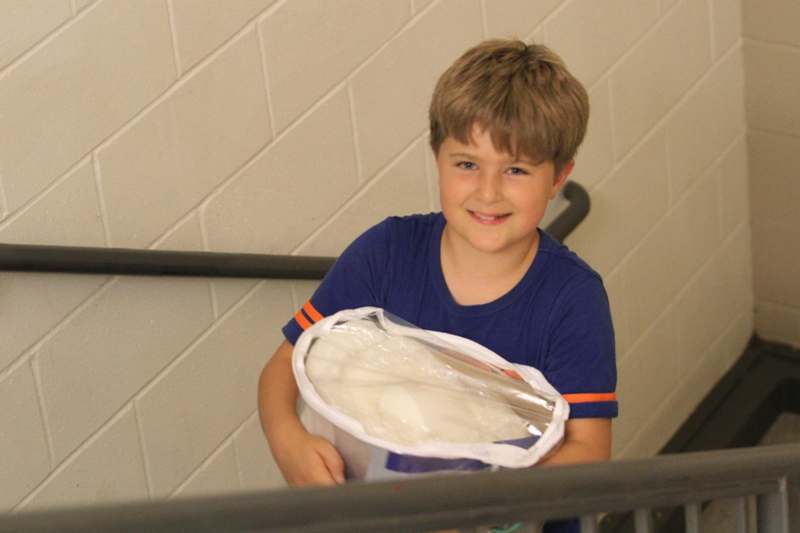 a boy holding a bucket of food