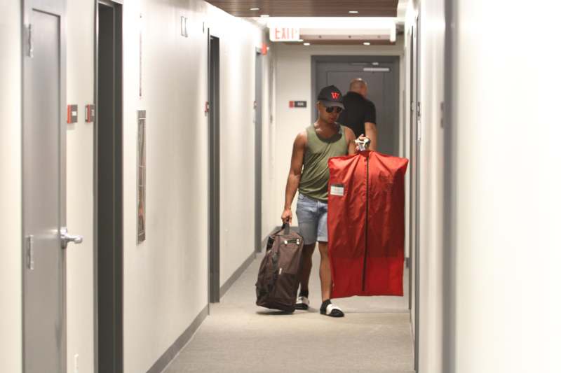 a man carrying luggage in a hallway