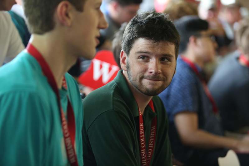 a man in green shirt with red lanyards
