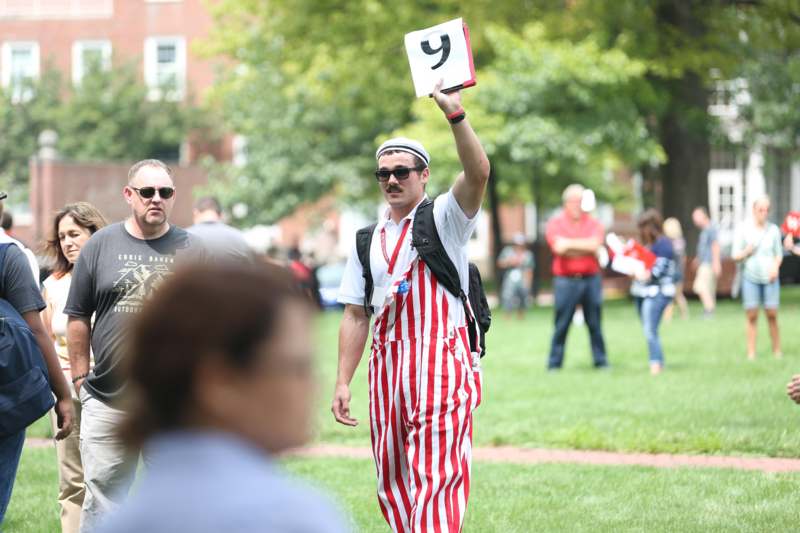 a man in striped overalls holding a sign