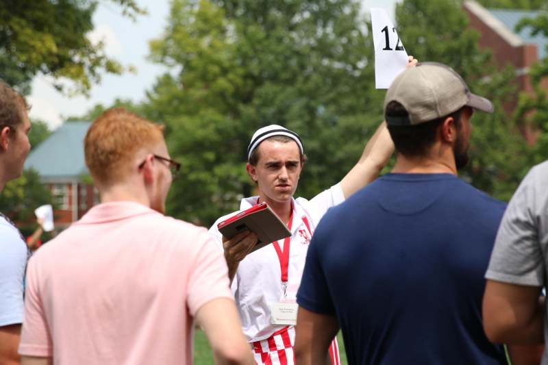 a man holding a sign with a group of people in the background