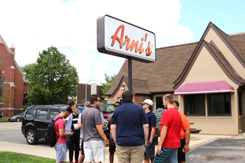 a group of people standing outside a restaurant
